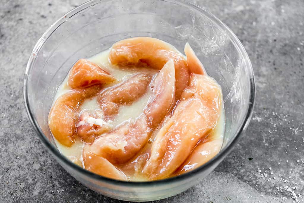 Chicken tenders marinating in pickle juice.