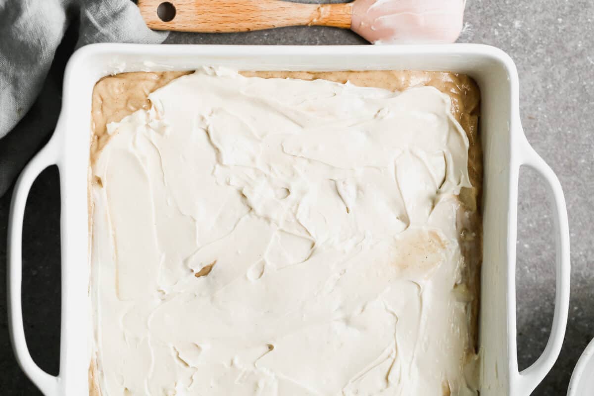 An Apple Coffee Cake with a cream cheese filling spread on top before baking.