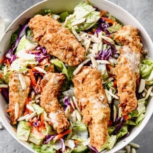 Applebees Chicken Salad in a serving bowl with dressing on top.