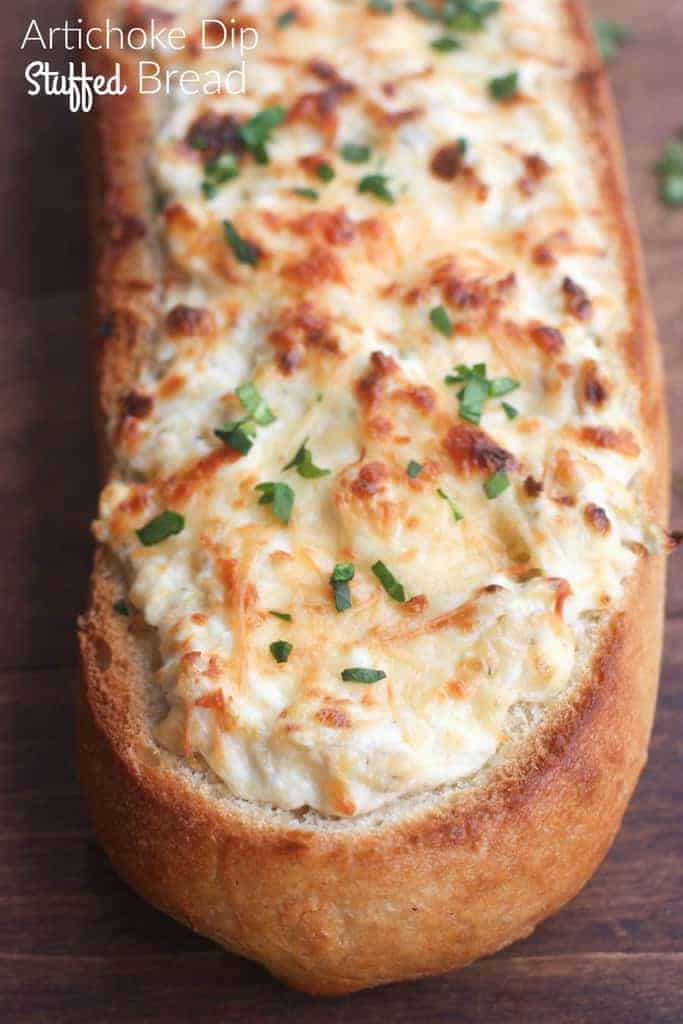 Artichoke Dip Stuffed Bread - our favorite hot artichoke dip recipe stuffed into a delicious crusty baguette. Makes a great, easy party appetizer!| Tastes Better From Scratch