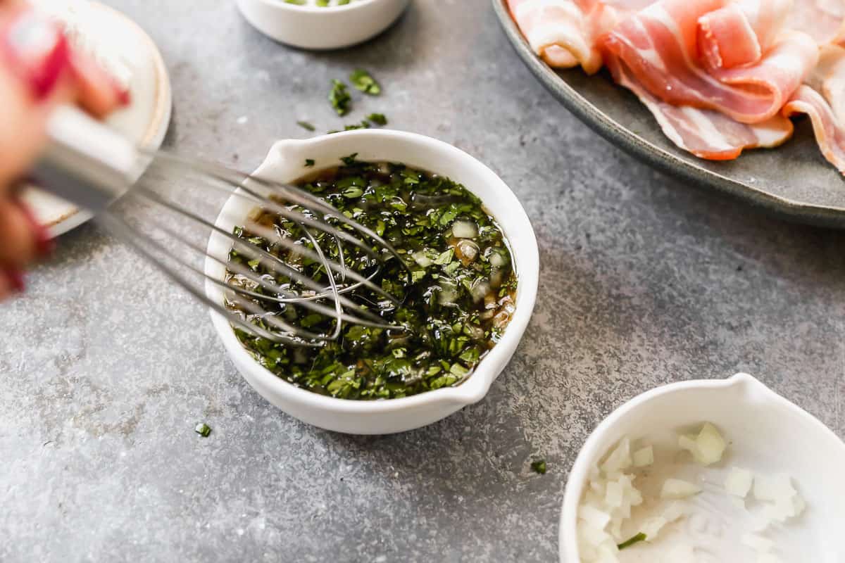 Maple syrup, cilantro, sweet onion, and red pepper flakes being whisked together for a sweet glaze.