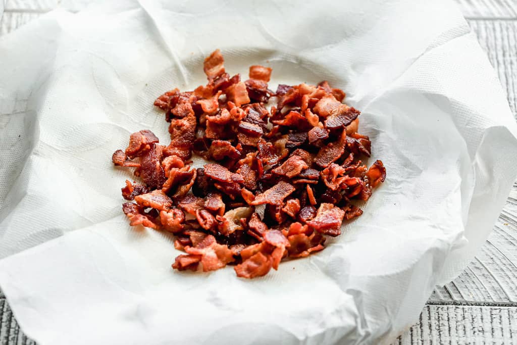 Crispy bacon pieces on a paper towel.