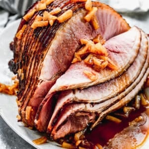 A spiral baked ham with a pineapple brown sugar glaze poured on top, ready to serve.