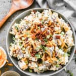 A serving bowl filled with easy Baked Potato Salad, ready to serve.