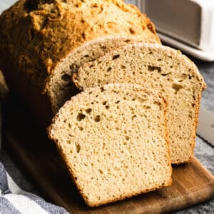 The best Beer Bread recipe on a cutting board, with a few slices sliced and ready to enjoy.