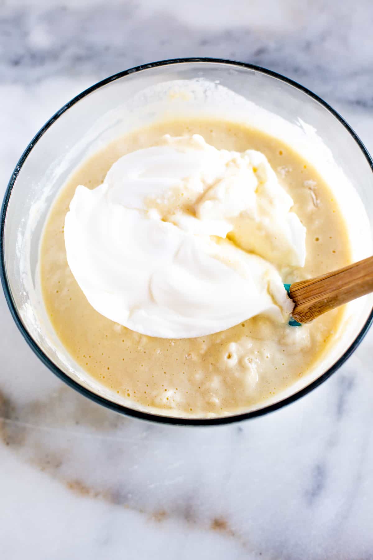 Egg whites being folded into a waffle batter to make them light and fluffy.