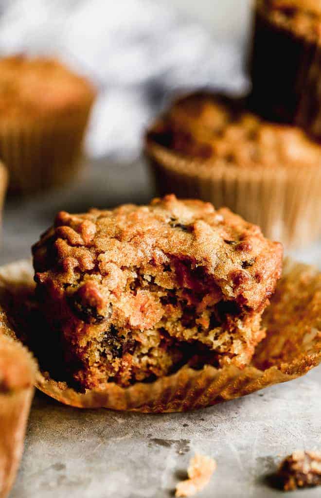 A bran muffin with a bite taken out of it.