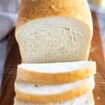 A loaf of homemade bread with three slices cut from it.