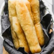 Long thin homemade breadsticks in a basket.