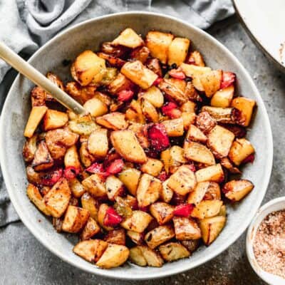 A bowl of crispy Breakfast Potatoes with bell peppers and onion, ready to serve.