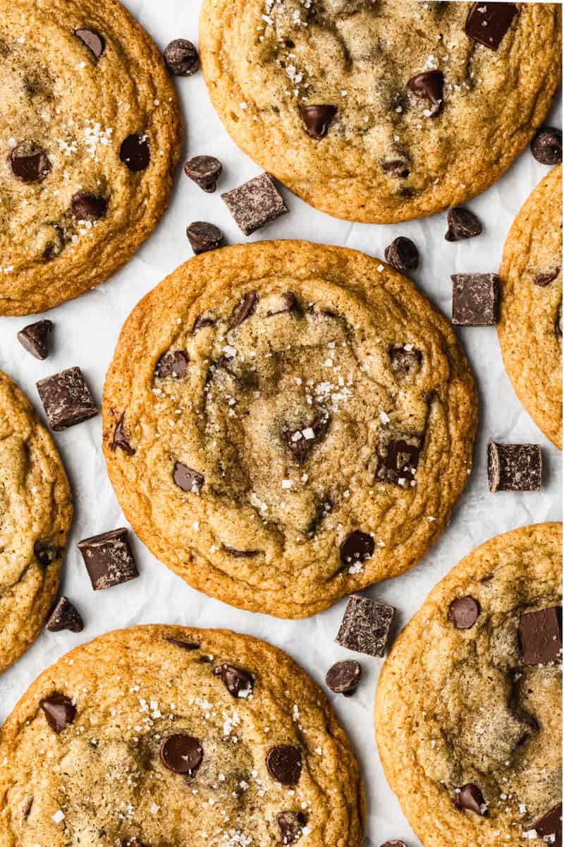 The best Browned Butter Chocolate Chip cookies recipe freshly baked on a piece of parchment paper, sprinkled with sea salt.