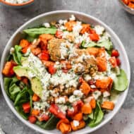 A homemade Buddha Bowl recipe with grains, roasted vegetables, falafel, and topped with a jalapeño ranch dressing.