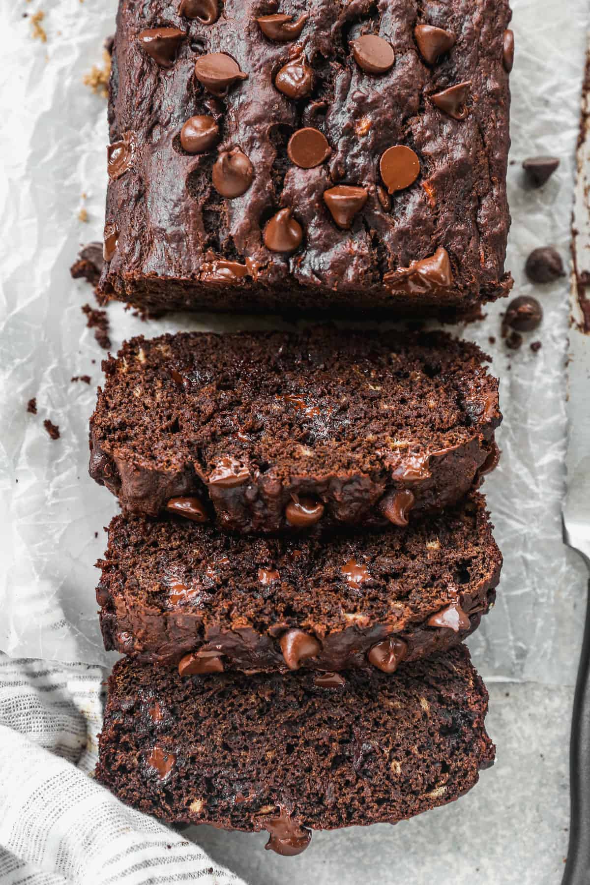 A loaf of easy Chocolate Banana Bread with three slices cut and ready to eat.