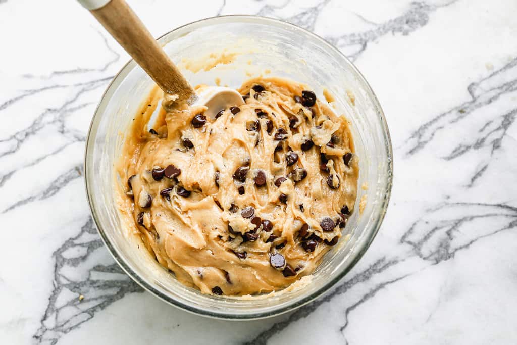 Chocolate chip cookie dough in a mixing bowl, ready to be scooped.