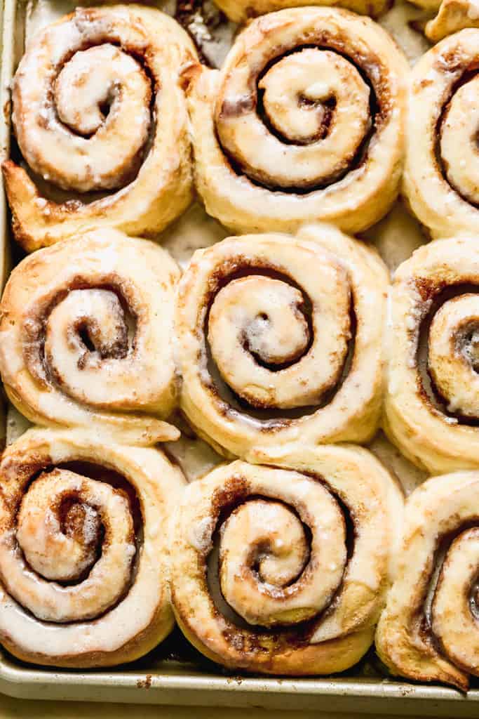 Baked cinnamon rolls on a sheet pan.