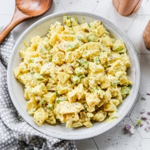 A white serving bowl filled with homemade classic Potato Salad, ready to serve.