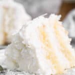 A slice of homemade Coconut Cake with pineapple filling on a plate ready to serve.