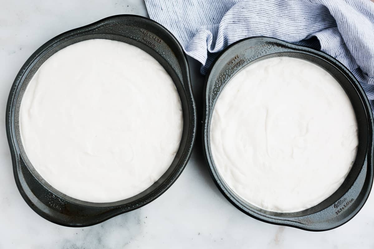 Two round cake pans filled with easy Coconut Cake batter.