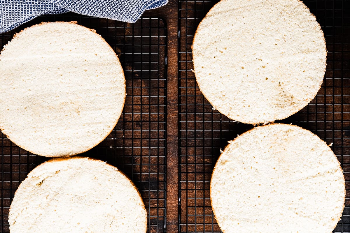 Two Coconut Cake rounds sliced in half to make four layers of cake.