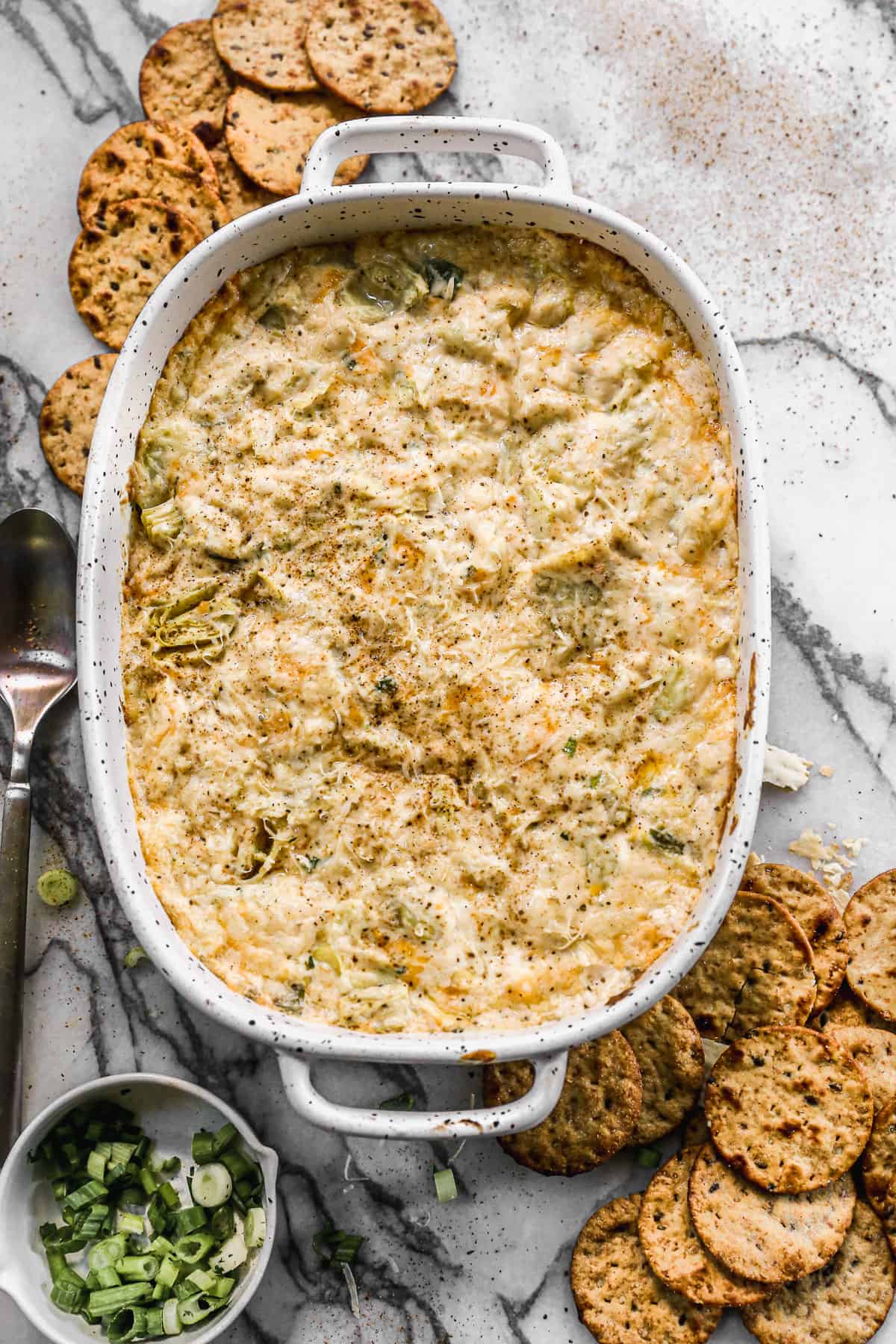 The best Crab Artichoke Dip in an oval pan, fresh out of the oven.