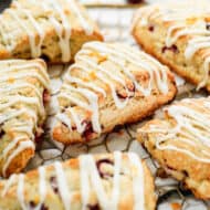 Homemade cranberry orange scones arranged on a decorative wire rack.