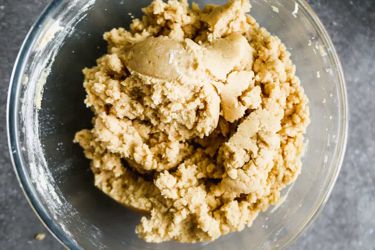 A glass mixing bowl filled with the best edible cookie dough base.