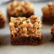 Cut German chocolate brownies served on a white board.