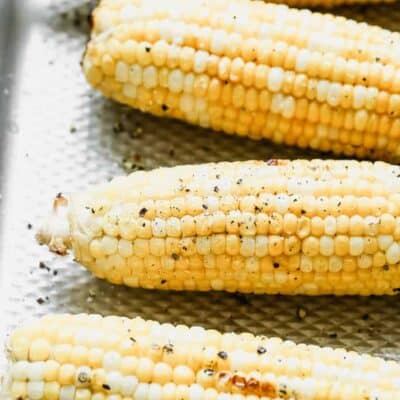 Grilled corn ears on a baking sheet.