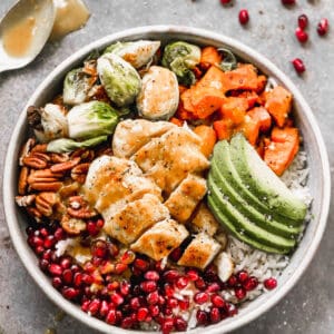 Harvest Bowls served over coconut rice, in a bowl, and topped with chicken and veggies.