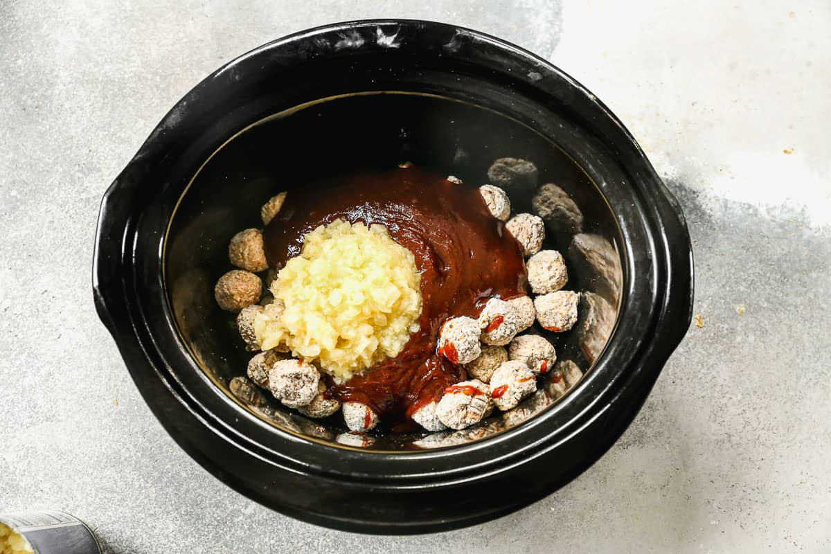 BBQ Sauce and diced pineapple dumped in a slow cooker on top of frozen meatballs for a Hawaiian meatballs sauce.