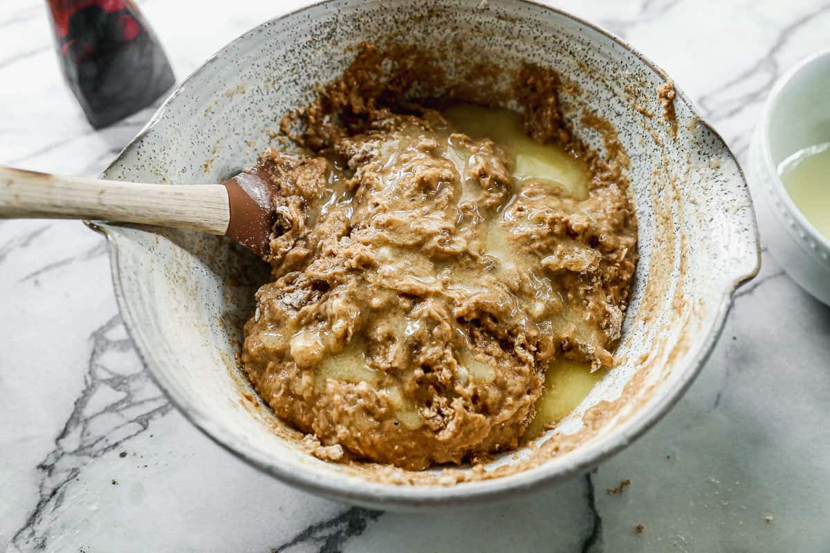 Melted butter poured on top of a healthy banana muffin batter.