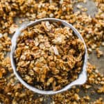 An easy homemade granola recipe in a bowl on a baking sheet.