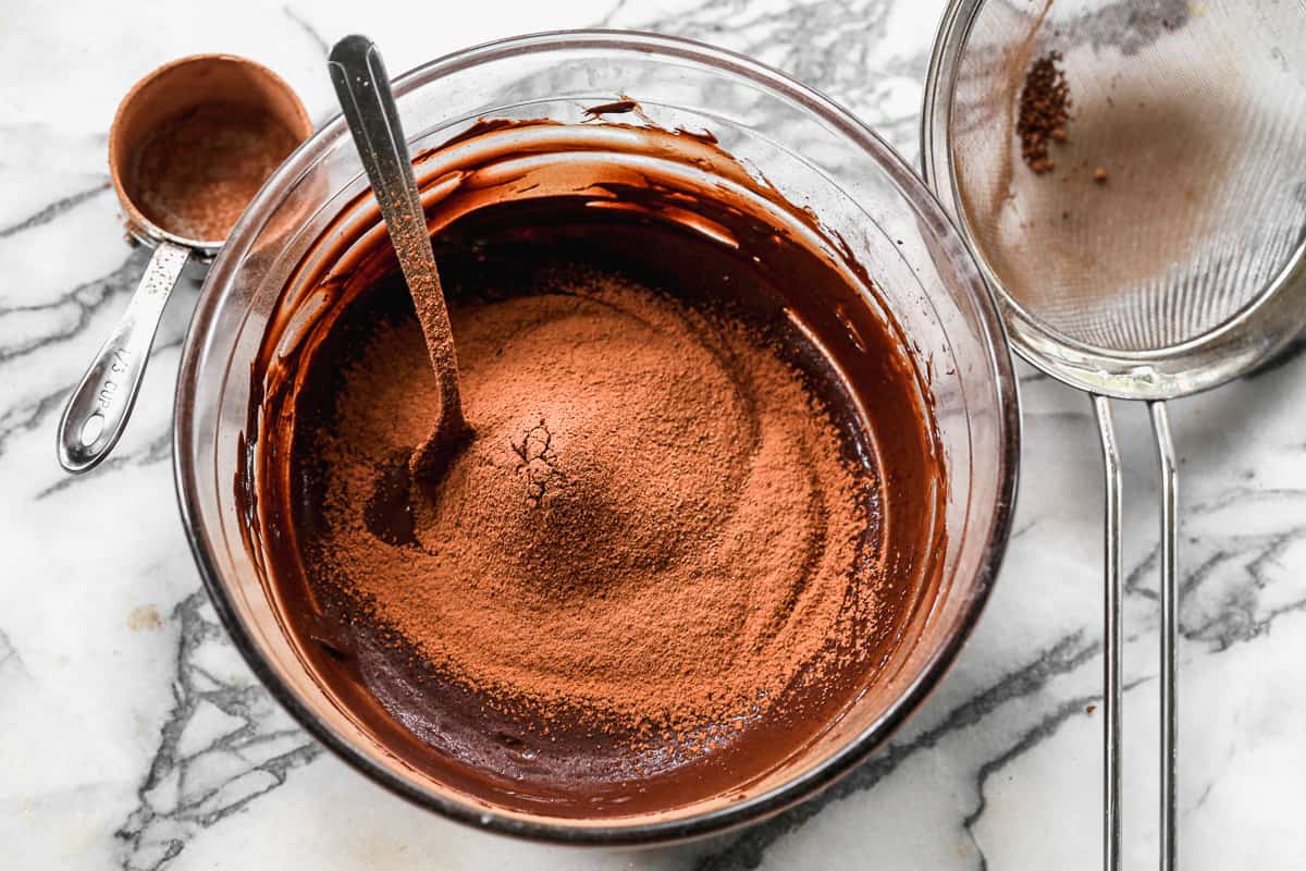 Cocoa powder being added to melted chocolate for the best Hot Fudge.