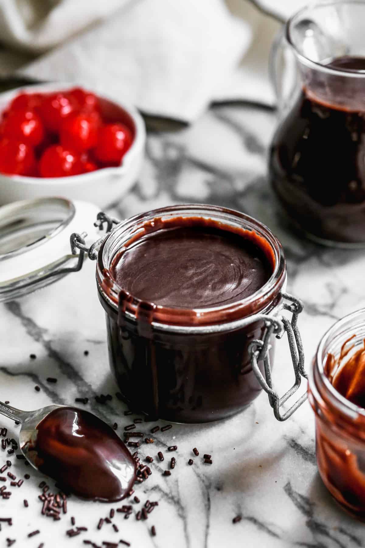 A glass container filled with homemade hot fudge, ready to enjoy.