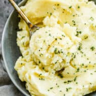 Instant Pot Mashed Potatoes served in a bowl, with a serving spoon.