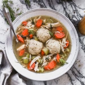 An easy Matzo Ball Soup recipe with carrots, celery, shredded chicken, and three homemade matzo balls.