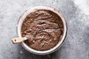 Flour and salt added to wet ingredients to make brownie batter.