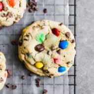 A close up image of a M&M Cookie on a cooling rack.