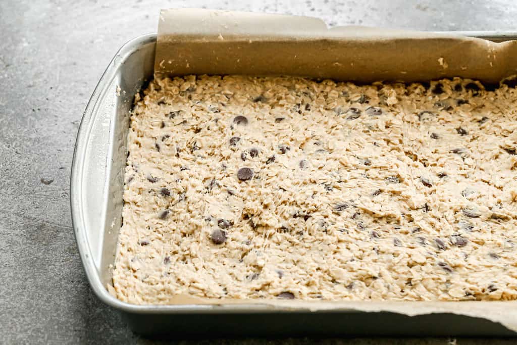 A 9x13 inch pan with oatmeal cookie bar dough in it, ready to bake.