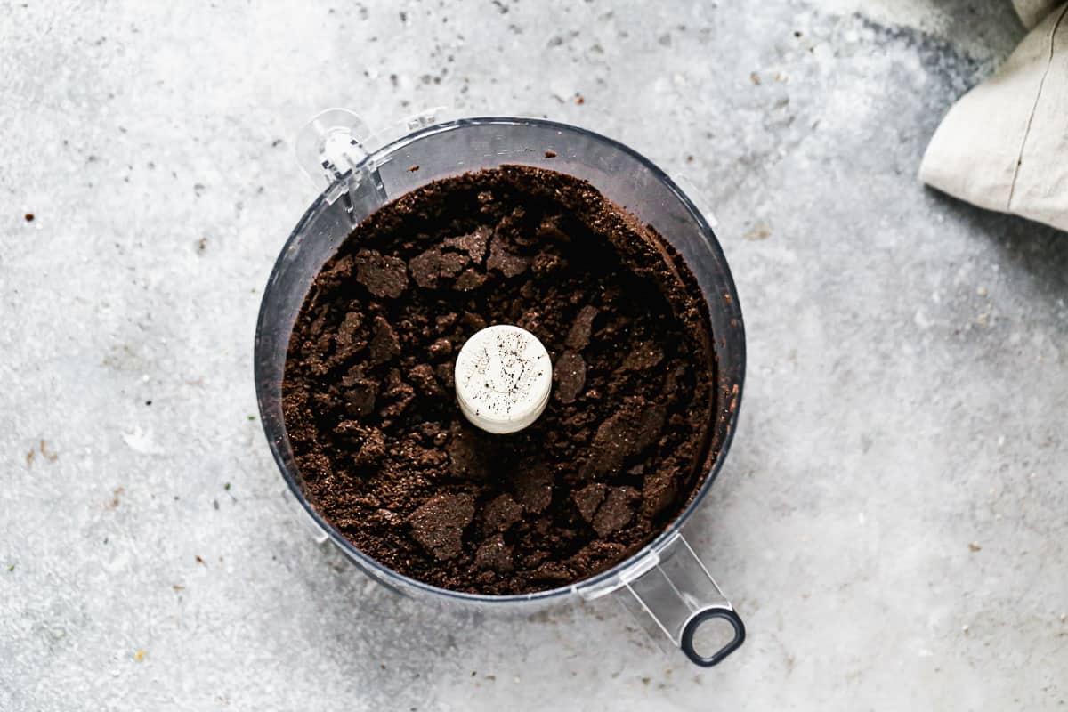 A food processor filled with Oreo cookies, all broken up.