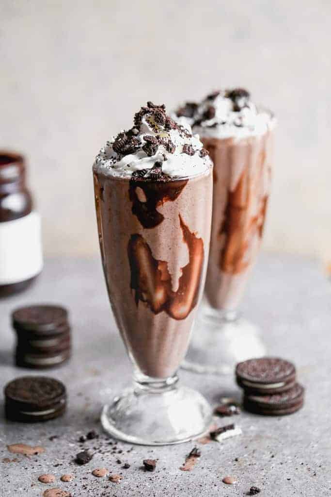 Two Oreo milkshakes served in fountain shoppe glasses.