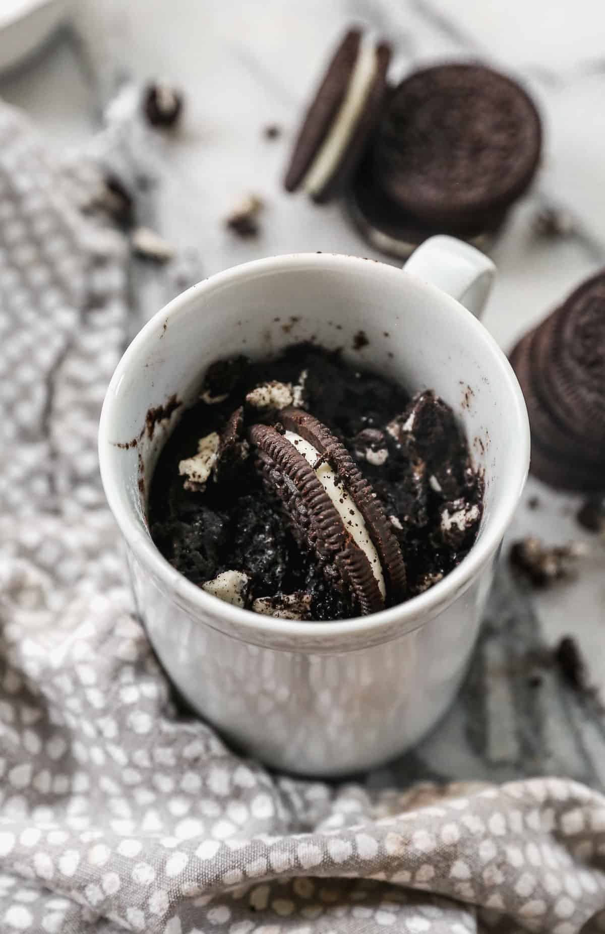 Oreo Mug Cake cooked in a white mug.