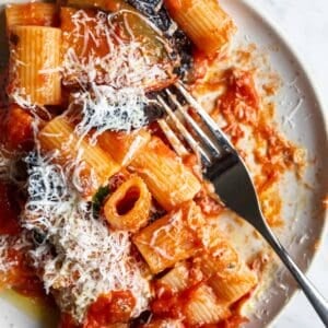 A plate of Pasta Alla Norma with parmesan cheese on top.