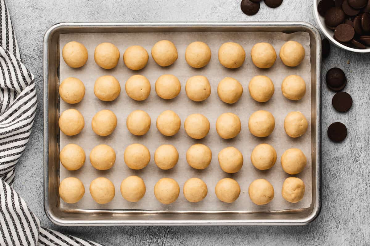 Peanut Butter Balls on a baking tray, ready to be dipped in chocolate.