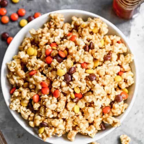 Peanut Butter Popcorn served in a bowl, with Reese's pieces candy in it.