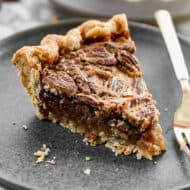 A slice of Pecan Pie on a plate with a fork, ready to enjoy!