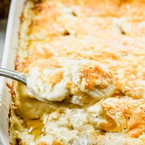 Baked Potatoes Au Gratin, with some of it being lifted with a spoon.