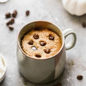 Pumpkin Mug Cake in a mug, with chocolate chips on top.