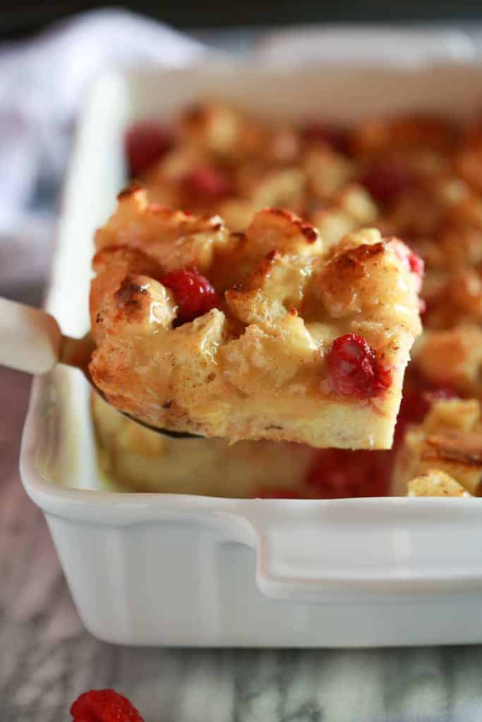 A spatula removing a piece of bread pudding from the pan.