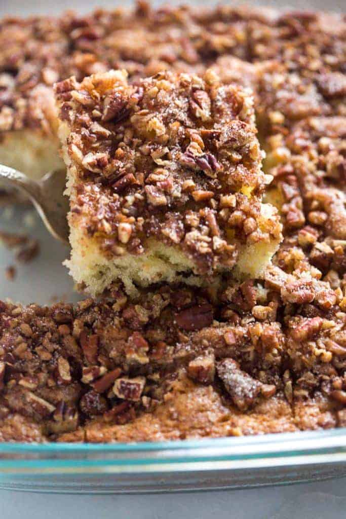 A glass pan with a slice of coffee cake being removed from it.